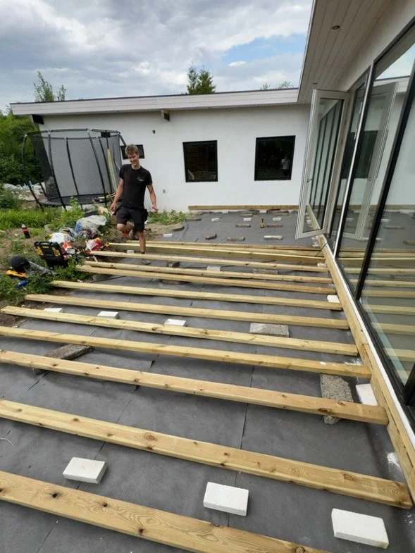 Tømrer i gang med at lægge strøer til en ny terrasse