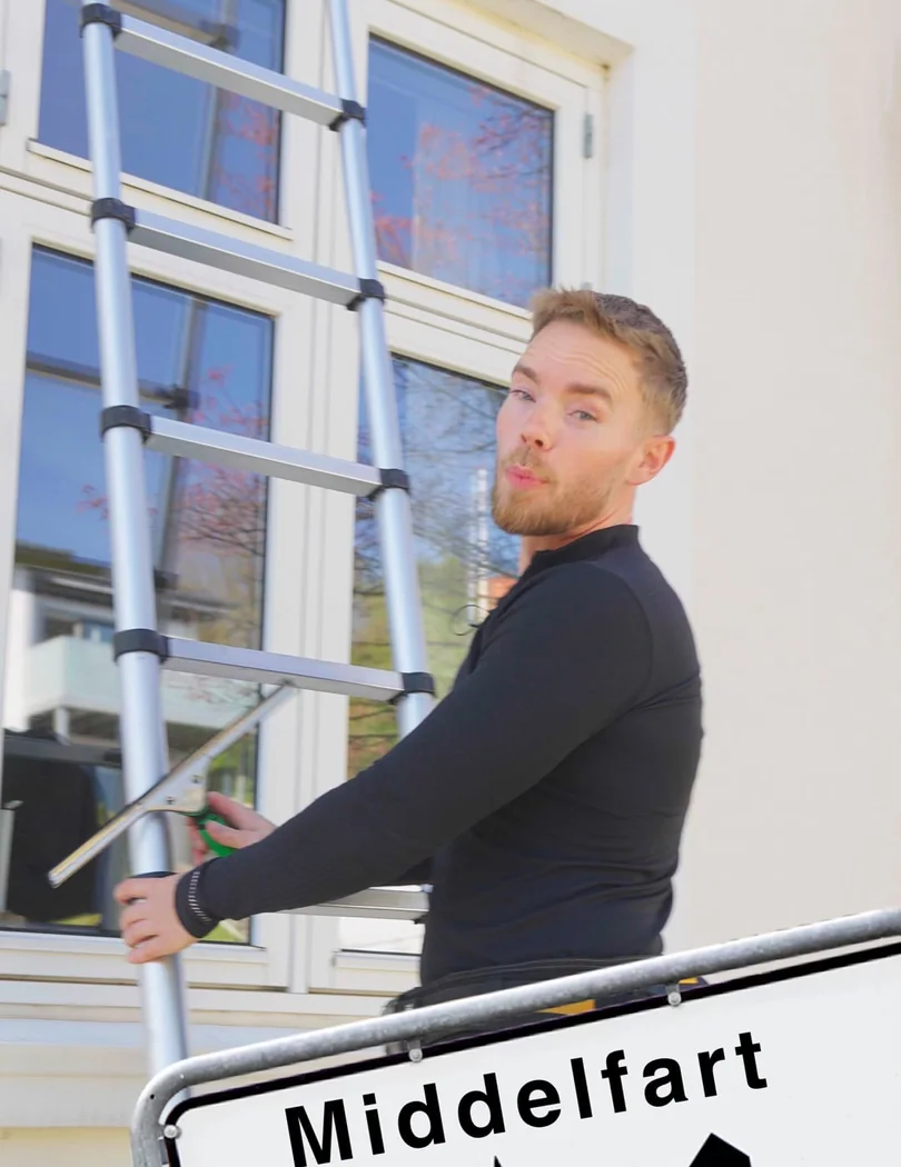 Vinduespudser fra Lokal Polering med skraber og stige ved et vindue
